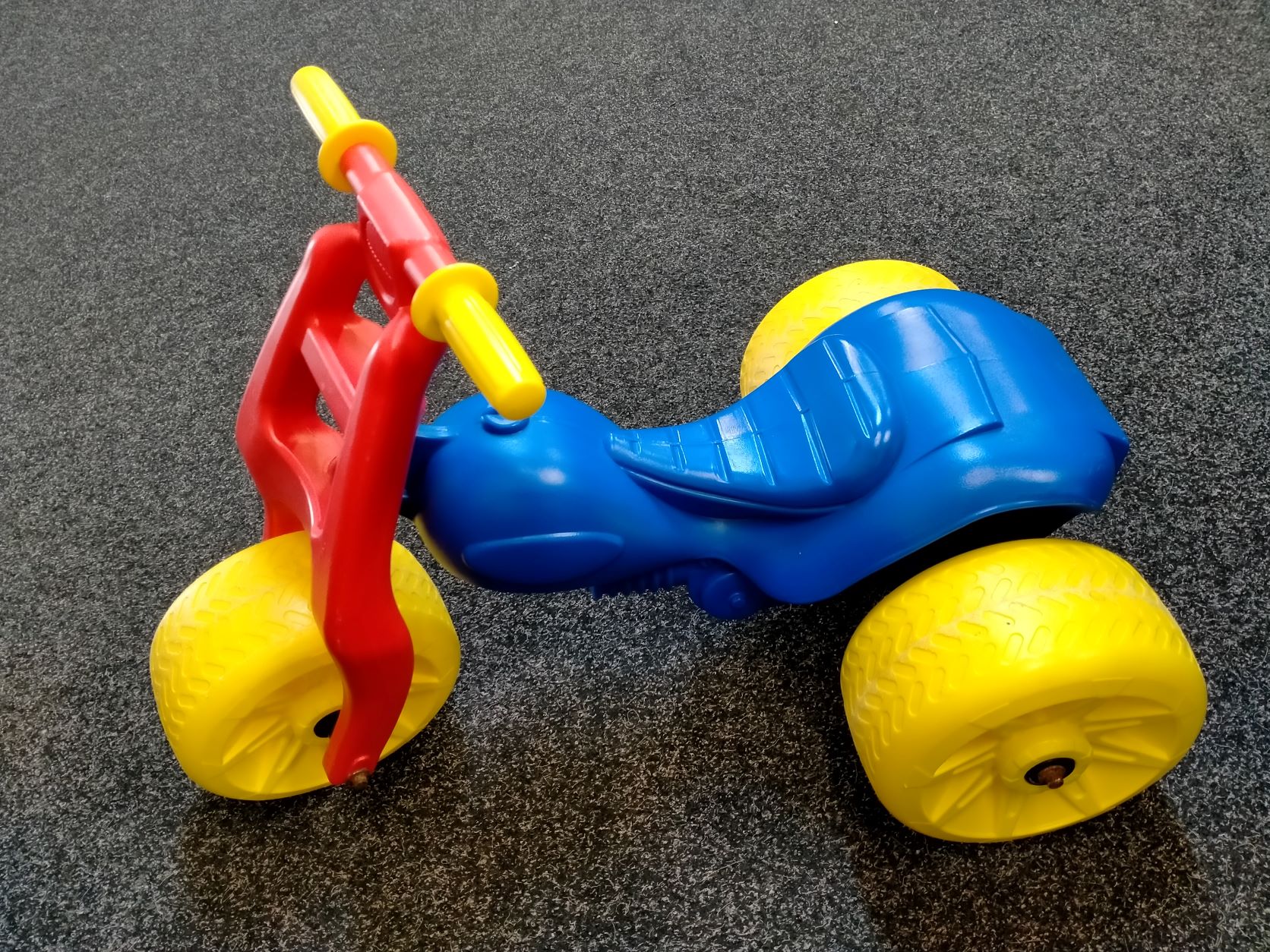 Toddler trike with 2 yellow handles 3 yellow wheels 1 red handlebar